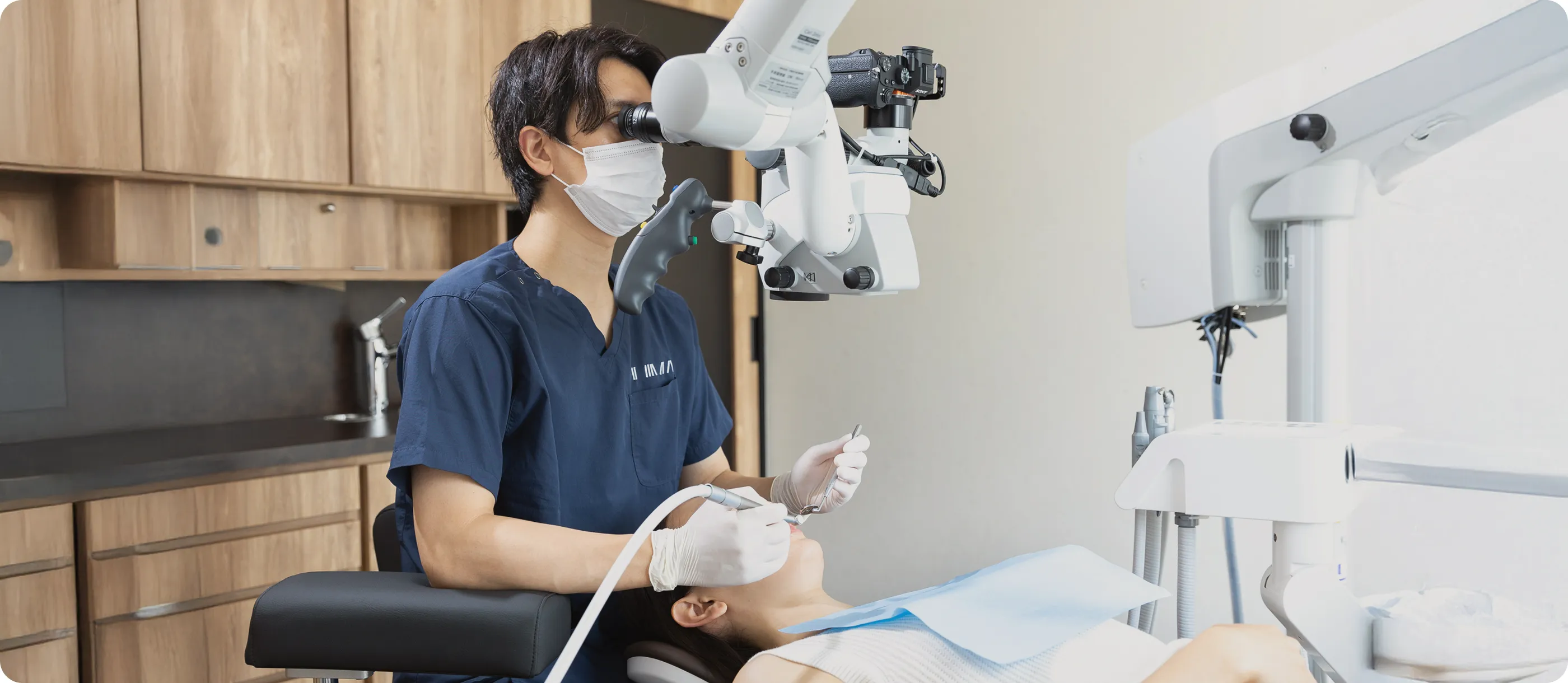 マイクロスコープを使って精密な歯科治療を行う歯科医師